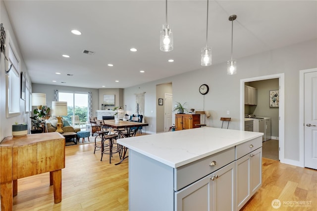 110 Blue Glacier Loop, Sequim, WA 98382 - kitchen featuring visible vents, a kitchen island, open floor plan, separate washer and dryer, and light wood finished floors