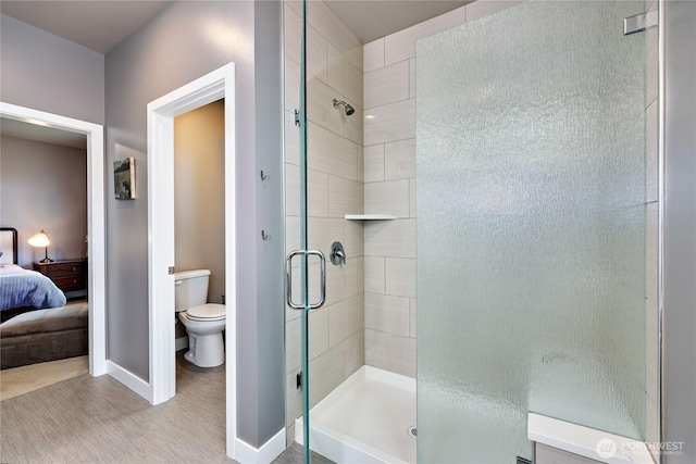 110 Blue Glacier Loop, Sequim, WA 98382 - bathroom featuring connected bathroom, toilet, baseboards, wood finished floors, and a stall shower