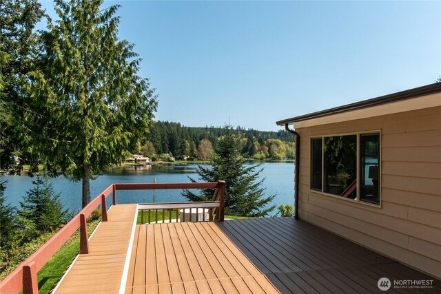 dock area with a wooded view and a deck with water view