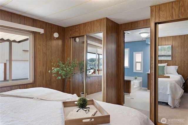 carpeted bedroom featuring wood walls