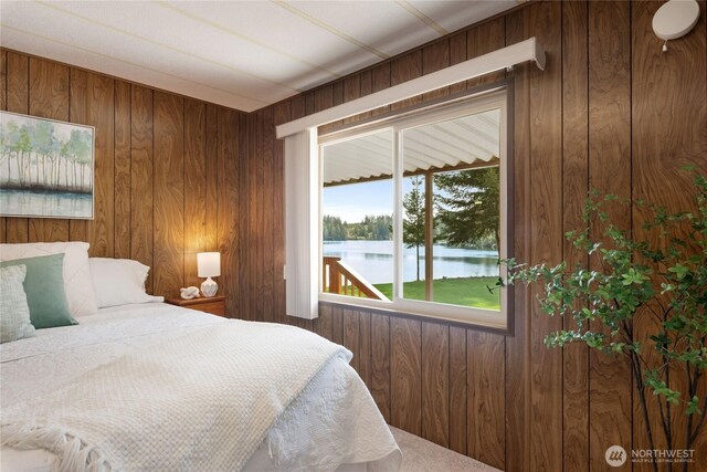 bedroom with wood walls and a water view
