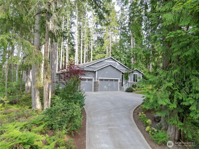 13978 Hidden Heights Ln NE, Bainbridge Island, WA 98110 - view of front of property with concrete driveway, an attached garage, and stone siding