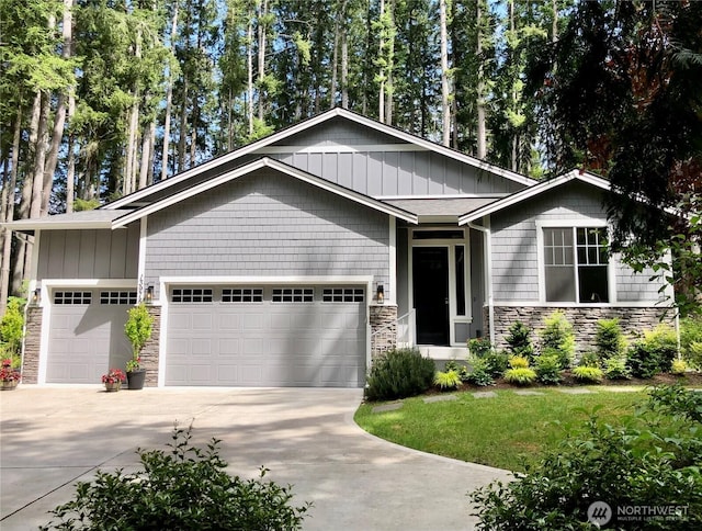 13978 Hidden Heights Ln NE, Bainbridge Island, WA 98110 - view of front facade with stone siding, an attached garage, concrete driveway, and a front yard