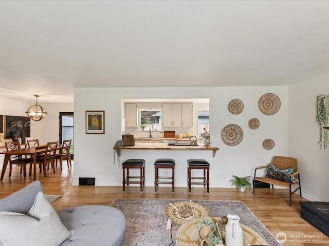 living room with a chandelier and light wood-type flooring