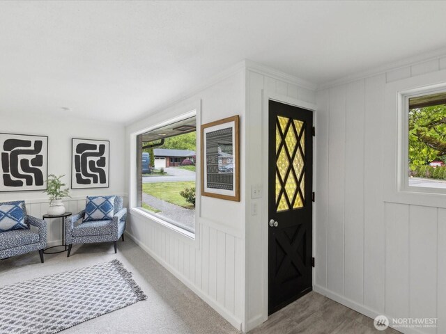 entrance foyer with a decorative wall and crown molding