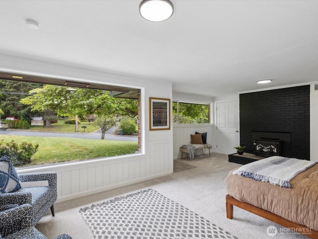 carpeted bedroom with a brick fireplace