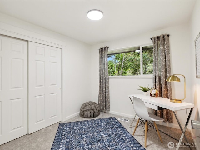 home office with baseboards and light carpet