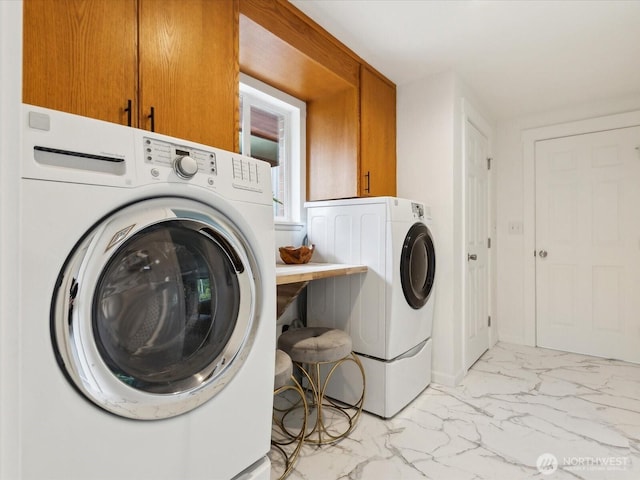 laundry room with light marble finish flooring, cabinet space, and washer and clothes dryer