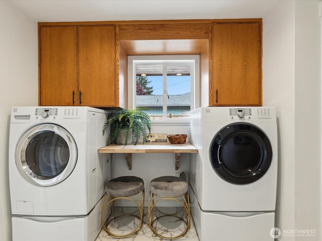 washroom featuring cabinet space and washer and clothes dryer