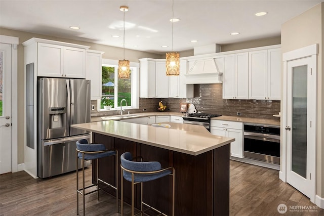 kitchen with a center island, dark wood-style flooring, appliances with stainless steel finishes, and tasteful backsplash