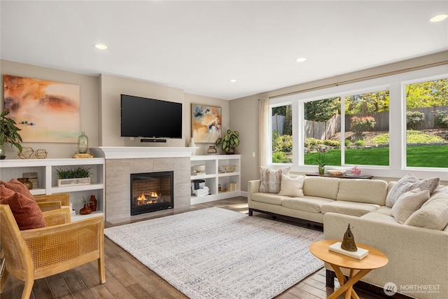 living room featuring recessed lighting, a fireplace, and hardwood / wood-style flooring