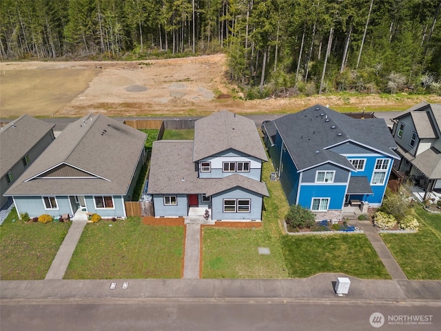 birds eye view of property featuring a forest view and a residential view