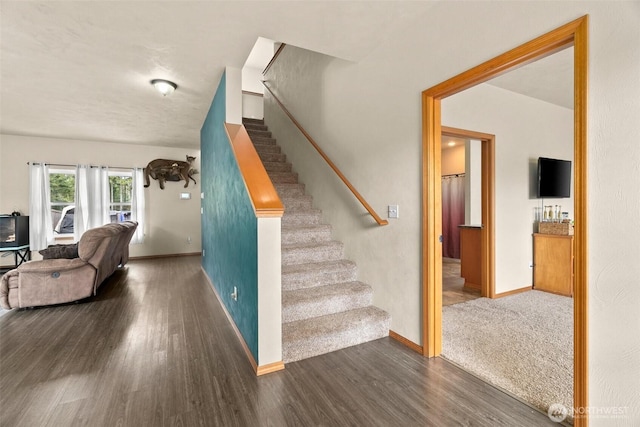 staircase with wood finished floors and baseboards