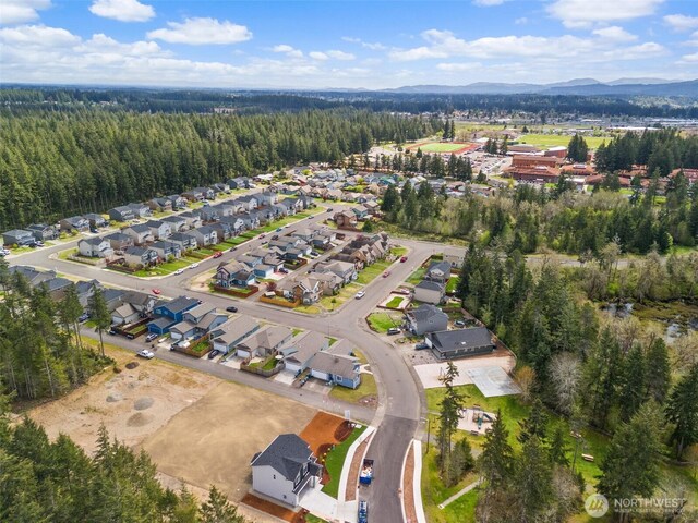 bird's eye view with a residential view, a mountain view, and a wooded view