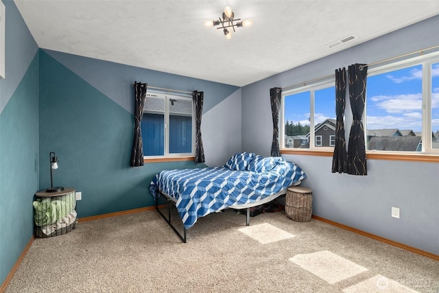 carpeted bedroom featuring baseboards and visible vents