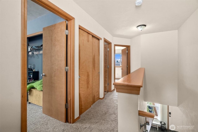 corridor featuring carpet floors and an upstairs landing