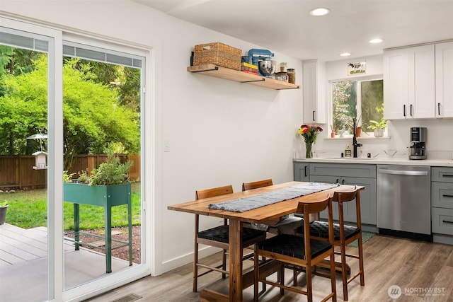 dining space with light wood finished floors and recessed lighting