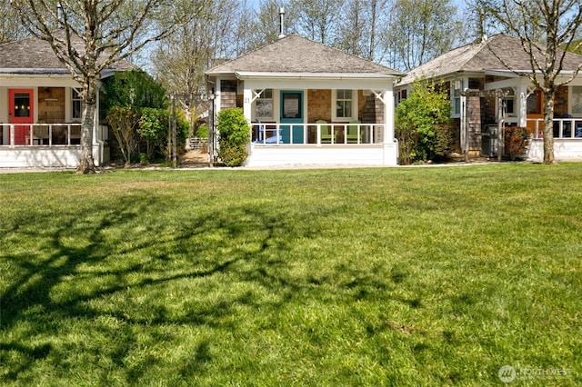 rear view of property featuring a sunroom and a yard