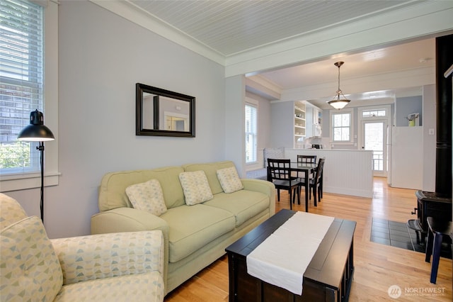 living room with light wood-style floors and ornamental molding