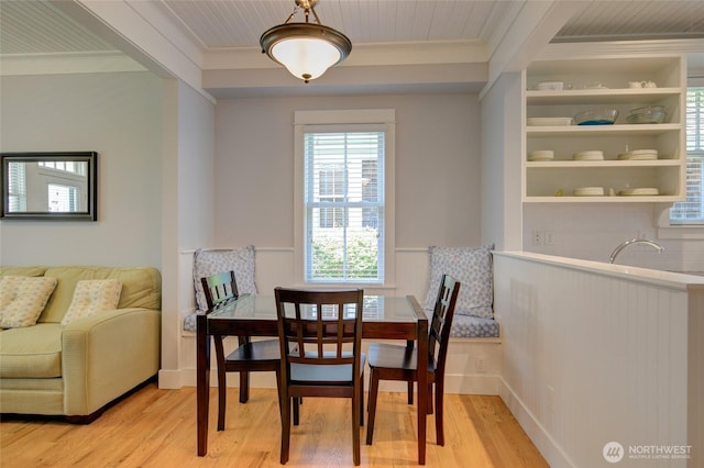 dining space featuring ornamental molding and light wood-type flooring