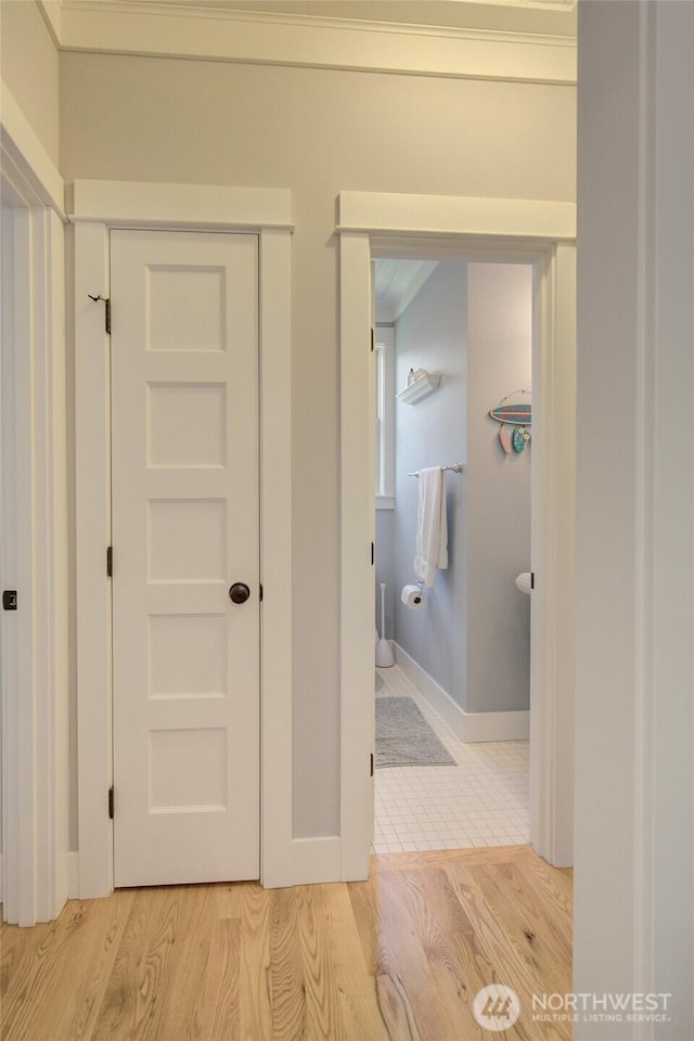hallway with light wood finished floors and baseboards