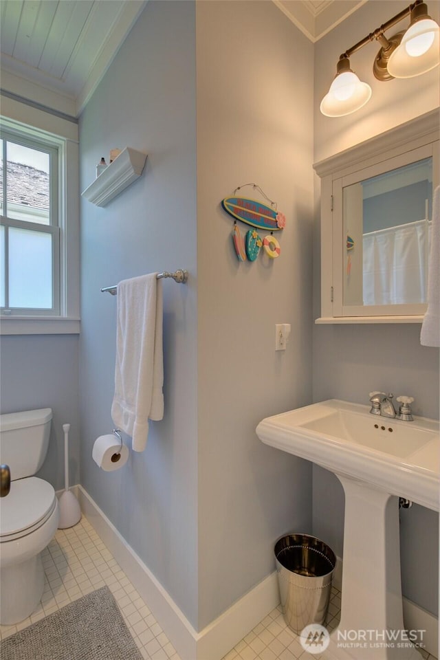 full bathroom featuring crown molding, toilet, baseboards, and tile patterned floors