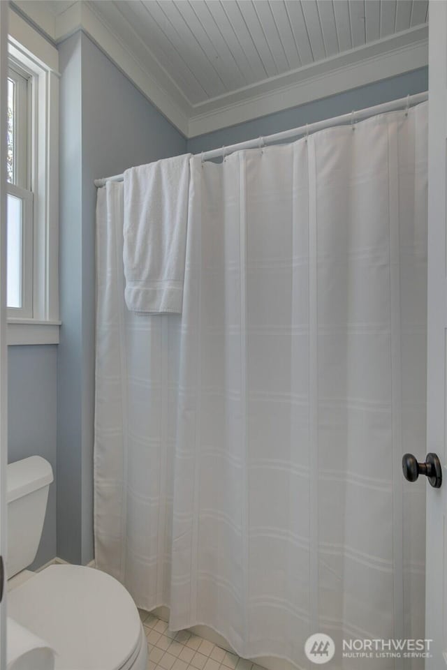 full bath with toilet, ornamental molding, and a shower with shower curtain