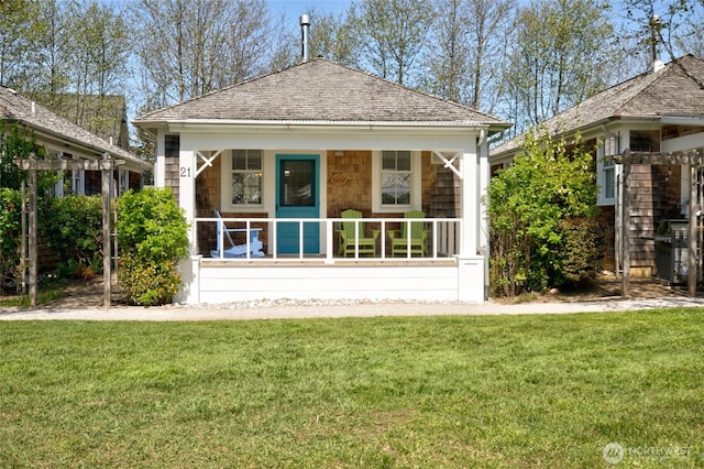 rear view of property featuring a porch and a lawn