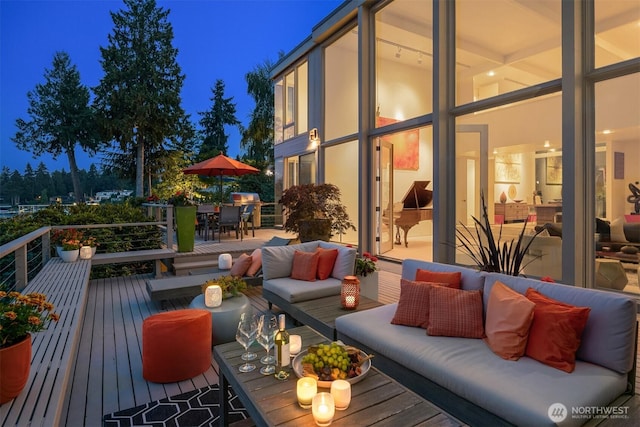 deck at night with an outdoor living space and outdoor dining space