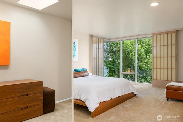 carpeted bedroom featuring recessed lighting, a skylight, and multiple windows