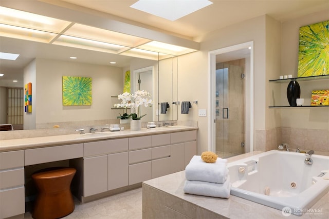 bathroom featuring a sink, a whirlpool tub, a stall shower, double vanity, and a skylight