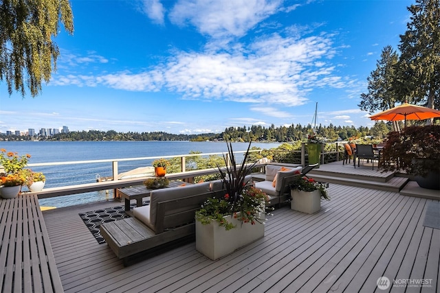 wooden terrace with outdoor dining space and a water view