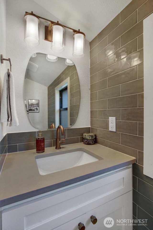 bathroom with vanity and tile walls