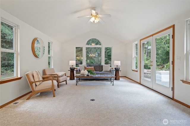 carpeted living area with lofted ceiling, a wealth of natural light, ceiling fan, and visible vents