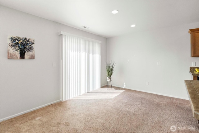unfurnished room featuring carpet floors, baseboards, and visible vents