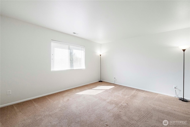 spare room with baseboards and carpet