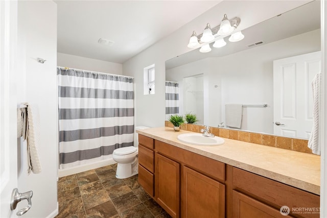 bathroom featuring vanity, toilet, stone finish floor, a shower with curtain, and visible vents