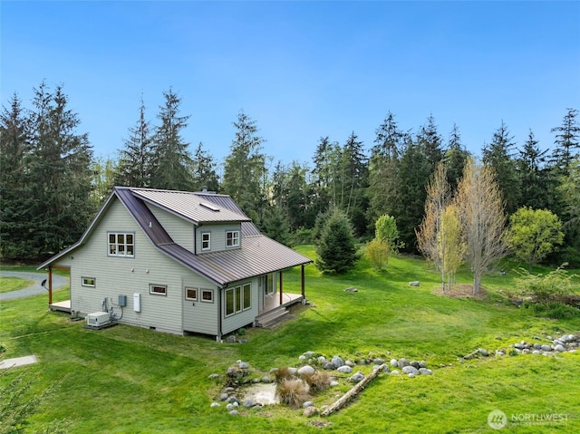 rear view of property with a yard and metal roof