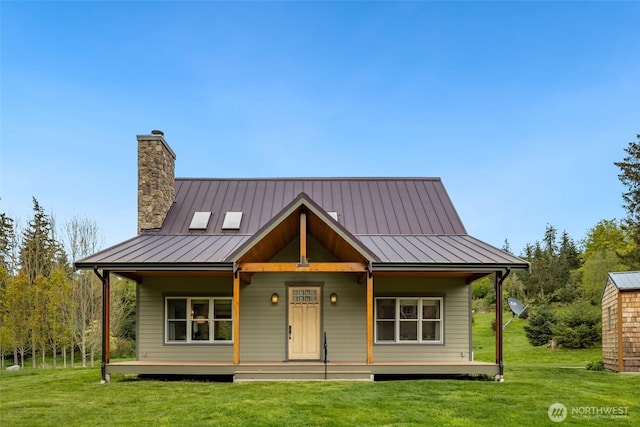 view of front of home with a front lawn, a porch, a standing seam roof, and a chimney