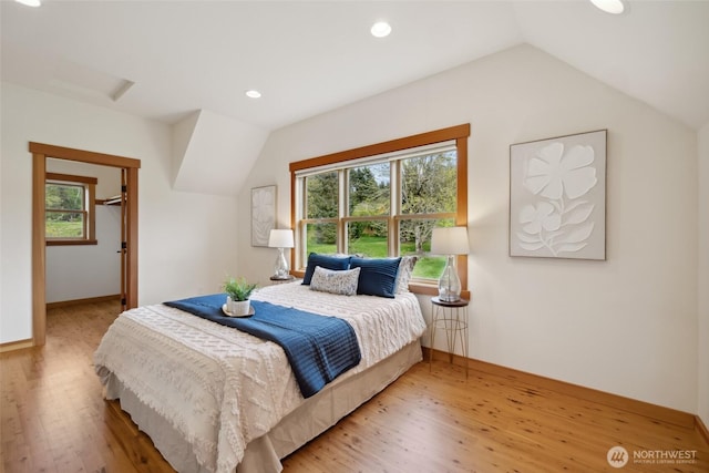 bedroom with recessed lighting, vaulted ceiling, wood finished floors, and multiple windows