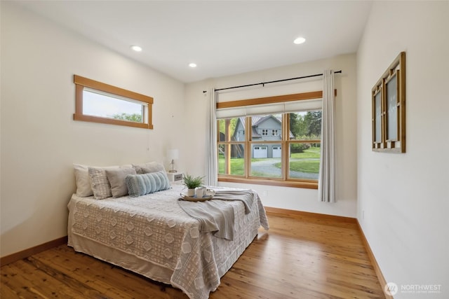 bedroom with recessed lighting, wood finished floors, and baseboards