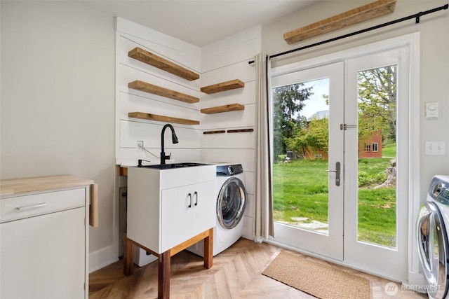 laundry area featuring washer / dryer, cabinet space, and a sink