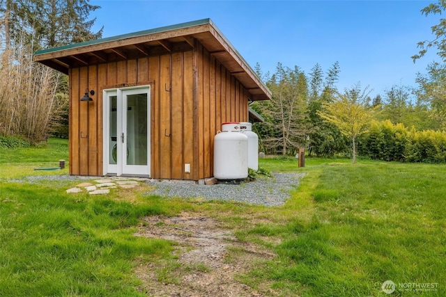 exterior space with an outdoor structure, a yard, and board and batten siding