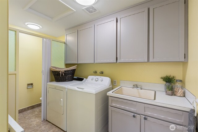 laundry room featuring a sink, washing machine and clothes dryer, cabinet space, and visible vents