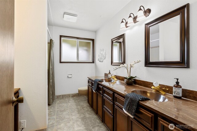 bathroom with vanity, curtained shower, and toilet