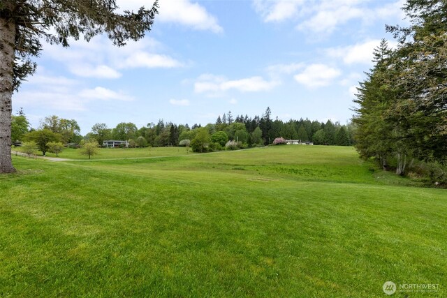 view of home's community featuring golf course view and a yard