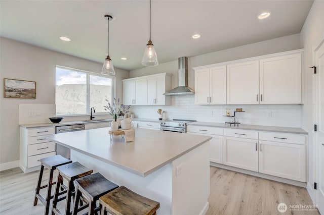 1580 S Kelvin Ct, East Wenatchee, WA 98802 - kitchen featuring wall chimney exhaust hood, a kitchen bar, appliances with stainless steel finishes, backsplash, and a kitchen island