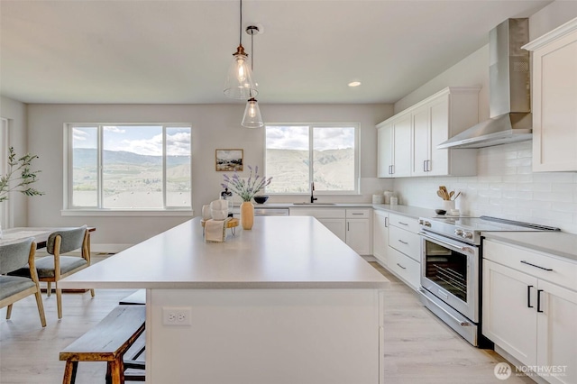 1580 S Kelvin Ct, East Wenatchee, WA 98802 - kitchen featuring high end stove, wall chimney range hood, a sink, plenty of natural light, and recessed lighting