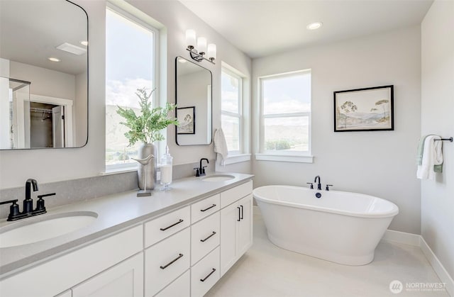 1580 S Kelvin Ct, East Wenatchee, WA 98802 - full bathroom with double vanity, healthy amount of natural light, a freestanding bath, baseboards, and recessed lighting