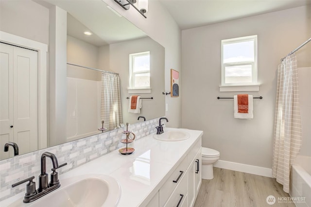 1580 S Kelvin Ct, East Wenatchee, WA 98802 - bathroom featuring double vanity, wood finished floors, toilet, backsplash, and shower / tub combo
